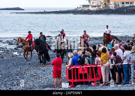 Una folla di persone in attesa per l arrivo dei cavalli sulla spiaggia di San Sebastian fiesta in La Caleta, Costa Adeje, Tenerife, Isole Canarie. Foto Stock