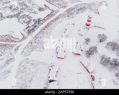 Vista panoramica dei colorati edifici in legno con vista dall'alto. Villaggio di pescatori e città turistica. Case rosse di legno del villaggio di pescatori in nevoso coperto in inverno. Foto Stock