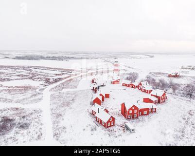 Vista panoramica dei colorati edifici in legno con vista dall'alto. Villaggio di pescatori e città turistica. Case rosse di legno del villaggio di pescatori in nevoso coperto in inverno. Foto Stock