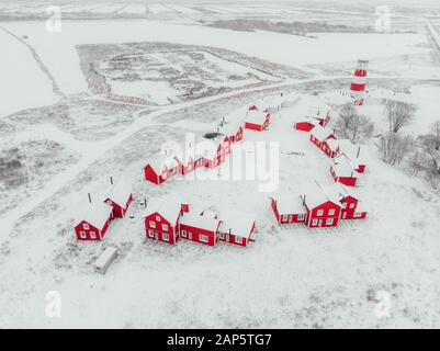 Vista panoramica dei colorati edifici in legno con vista dall'alto. Villaggio di pescatori e città turistica. Case rosse di legno del villaggio di pescatori in nevoso coperto in inverno. Foto Stock