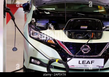 La carica di un electric Nissan Leaf con la potenza di alimentazione del cavo collegato alla presa di corrente, Praga Cechia, novembre 2019. Foto Stock