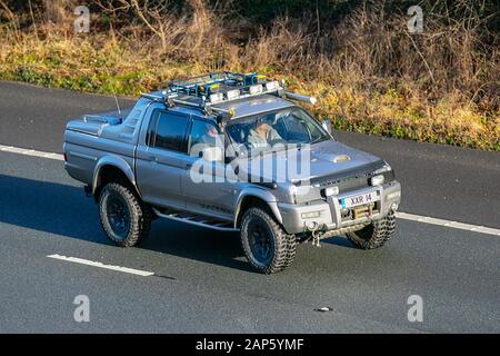 2004 argento Mitsubishi L200 Warrior LWB; traffico veicolare, trasporti, moderne, berline, a sud sulla M61 autostrada, Manchester, Regno Unito Foto Stock