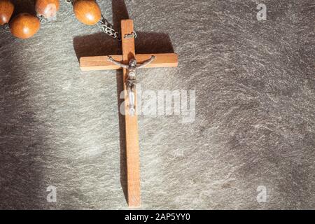 In legno antico rosario francescano, sulla grande croce cristiana Gesù, un  raggio di sole illumina il rosario su una pietra grigio Sfondo, religiosi e  f Foto stock - Alamy