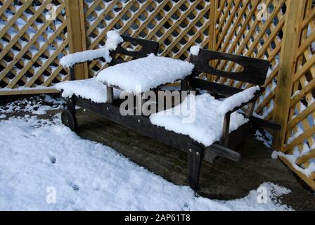 Due letti singoli, posto a sedere in legno all'esterno e coperto di neve Foto Stock