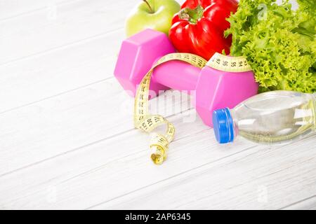 Il concetto di fitness con manubri e cibo sano. Foto Stock