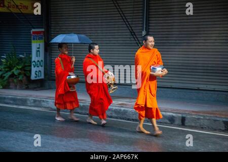 Una tradizione profondamente radicata nella cultura buddista, è la consegna durante la mattina delle offerte ai monaci che viaggiano intorno ai templi Foto Stock