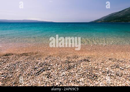 Le pietre sotto l'acqua. Ciottoli di mare sulla spiaggia. Ciottoli di mare sulla spiaggia di sabbia con acqua trasparente. Naturale di mare pietre closeup. Spiaggia di ciottoli lisci. Foto Stock