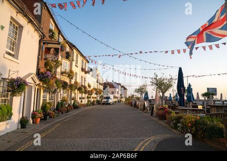 Deal England - 19 agosto 2019; Street lungo di fronte pub e ristoranti con posti a sedere all'aperto e Union Jack volare. Foto Stock