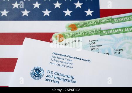 Stati Uniti le carte verdi permanenti residenti da dv-lottery si trovano sulla bandiera degli Stati Uniti con busta da parte del Dipartimento di sicurezza interna primo piano Foto Stock