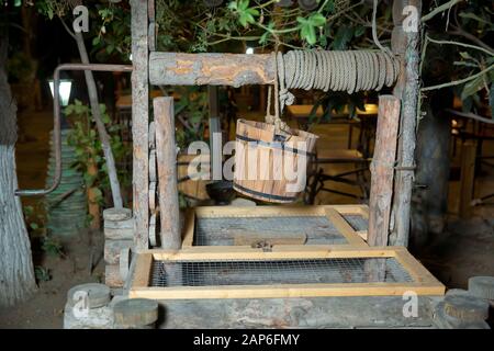 Un vecchio pozzo e un secchio di acqua .vecchio pozzo di legno acqua .vecchie pietre e pozzi di legno .bene e il taglio della benna per fare la foto composita . Stonegate Foto Stock