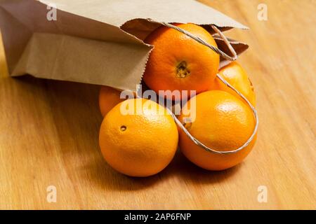 Arance che fuoriesce da un sacchetto di carta Foto Stock