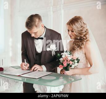 primo piano. la coppia felice firmando un contratto di matrimonio. Foto Stock