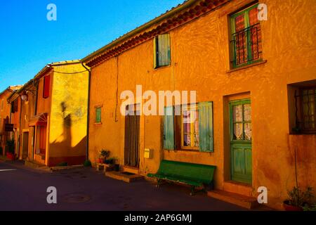 Roussillon En Provence, Francia - 2 Ottobre. 2019: Vista sulla facciata di tipiche case rosse gialle contro il cielo blu Foto Stock