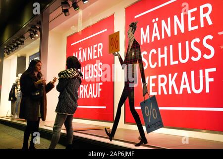 Dortmund, Germania, gennaio 21, 2020: i passanti nella parte anteriore del negozio finestra di uomini della casa di moda ANSON a Dortmund, si annuncia un uomo vendita per abbigliamento uomo. --- Di Dortmund, Germania, 21.Gen2020: Passanten vor dem Schaufenster des Herren-Modehauses ANSON a Dortmund, es wirbt Mit einem Männer-Schlußverkauf für Herrenbekleidung. Foto Stock