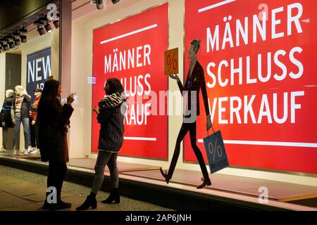 Dortmund, Germania, gennaio 21, 2020: i passanti nella parte anteriore del negozio finestra di uomini della casa di moda ANSON a Dortmund, si annuncia un uomo vendita per abbigliamento uomo. --- Di Dortmund, Germania, 21.Gen2020: Passanten vor dem Schaufenster des Herren-Modehauses ANSON a Dortmund, es wirbt Mit einem Männer-Schlußverkauf für Herrenbekleidung. Foto Stock