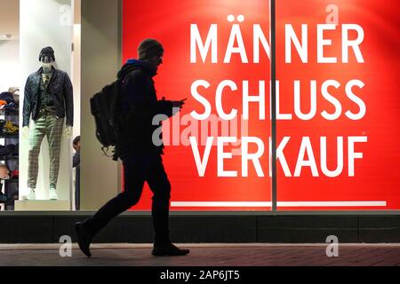Dortmund, Germania, gennaio 21, 2020: i passanti nella parte anteriore del negozio finestra di uomini della casa di moda ANSON a Dortmund, si annuncia un uomo vendita per abbigliamento uomo. --- Di Dortmund, Germania, 21.Gen2020: Passanten vor dem Schaufenster des Herren-Modehauses ANSON a Dortmund, es wirbt Mit einem Männer-Schlußverkauf für Herrenbekleidung. Foto Stock