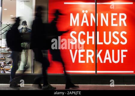 Dortmund, Germania, gennaio 21, 2020: i passanti nella parte anteriore del negozio finestra di uomini della casa di moda ANSON a Dortmund, si annuncia un uomo vendita per abbigliamento uomo. --- Di Dortmund, Germania, 21.Gen2020: Passanten vor dem Schaufenster des Herren-Modehauses ANSON a Dortmund, es wirbt Mit einem Männer-Schlußverkauf für Herrenbekleidung. Foto Stock