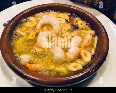 Grigliata di gamberi in olio d'oliva e aglio servita nel piatto ramkin Foto Stock