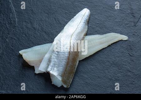 Due filetto di merlano crudo, Merlangius merlangus, da un merlano catturato nel canale inglese su Rod e linea da una barca. I filetti mostrano la carne e. Foto Stock