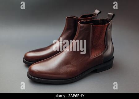 Scarpe, stivali in pelle chelsea per uomo. Moda maschile invernale, autunnale o primaverile. Calzature su sfondo grigio. Vendita Foto Stock