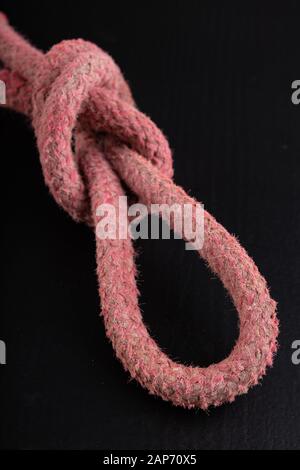 Anello in corda spessa. Nodo a forma di ansa. Sfondo scuro Foto Stock