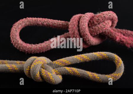 Due anelli fatti di corda spessa. Nodo a forma di ansa. Sfondo scuro. Foto Stock