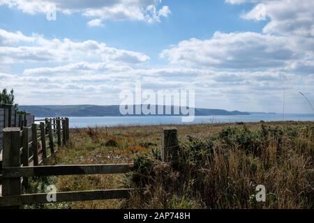 Guardando a sud-ovest dal South West Coast Path a Bude Bay con Chipman Point e Pencannow Point sulla costa nord della Cornovaglia in lontananza Foto Stock