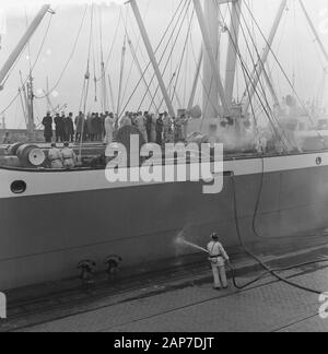 Incendio a bordo del Badagiy Palm nel Waalhaven a Rotterdam. I vigili del fuoco scendono in attesa con maschere ad ossigeno Data: Marzo 28, 1961 Location: Rotterdam, Zuid-Holland Parole chiave: incendi, vigili del fuoco nome personale: Badagiy Palm Foto Stock