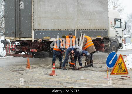 Città del servizio di emergenza di riparazione rottura tubo acqua in inverno. Foto Stock