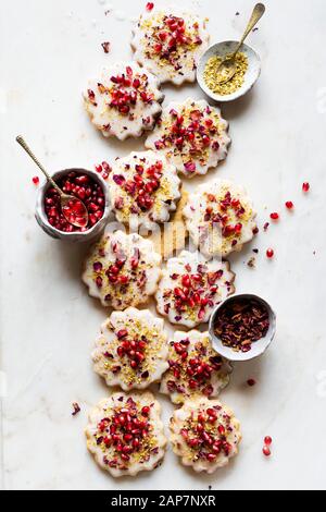 Senza glutine biscotti di zucchero con smalto eggless decorate con i semi di melograno, petali di rosa e pistacchio Foto Stock