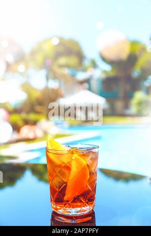 Cocktail Negroni presso il bar del resort o il patio della suite. Resort di lusso, vacanza, servizio in camera concetto. Verticale con festive bokeh luci effetto Foto Stock
