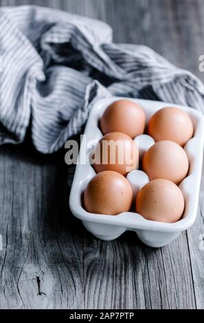 Sei uova in un piatto di uovo di ceramica con un tovagliolo. Foto Stock