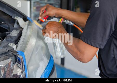 Mechanic la mano di lucidatura è la vettura del faro. Foto Stock