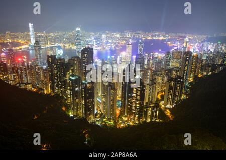 Vista notturna degli edifici moderni lungo il Victoria Harbour di Hong Kong Foto Stock