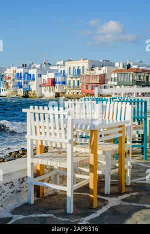 Sedie e tavoli in tipica taverna greca nella piccola Venezia parte della città di Mykonos, a Mykonos, Grecia Foto Stock