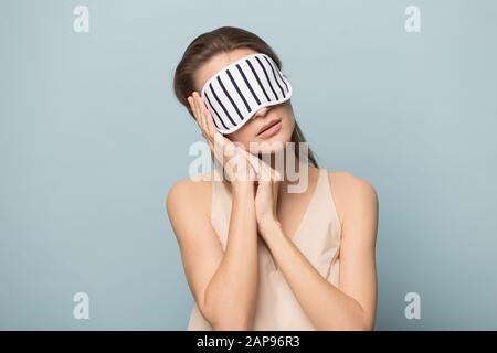 Stanco della donna nella maschera di sonno dormire tranquillamente in piedi Foto Stock