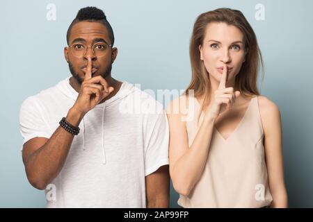 Diversi uomo e donna tenere un dito sulle labbra dicendo segreto Foto Stock