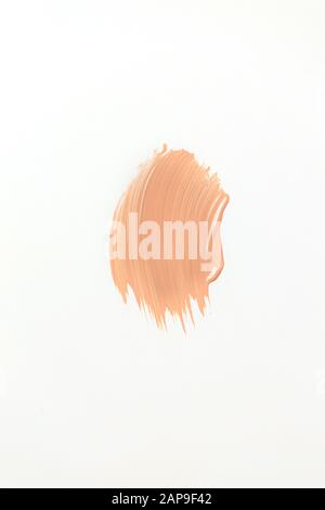 Tonalità beige sulla pelle sfumano su sfondo bianco isolato, texture crema Foto Stock