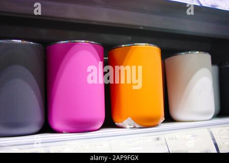 bicchieri colorati o contenitori di vari articoli domestici per qualsiasi uso domestico collocati su un ripiano in un negozio o scaffale in casa in italia Foto Stock