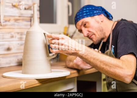 Potter artista finitura opere su nuova mano fatta tazza, concetto di piccola arte di affari, poco profondo debito di campo Foto Stock