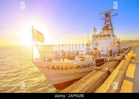 San Diego, Navy Pier, California, STATI UNITI - 1 agosto 2018: Tramonto sole contro la bandiera Jolly Roger della taglierina Farley Mowat. Pastore Di Mare Foto Stock