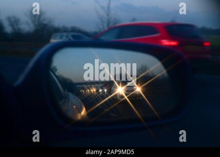 Le auto si riflettono nello specchio retrovisore ad ala del veicolo sulla strada a doppia carreggiata A64 all'alba di york, regno unito Foto Stock