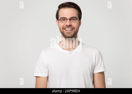 Felice sorridente ragazzo millennial indossando occhiali testa shot studio ritratto. Foto Stock