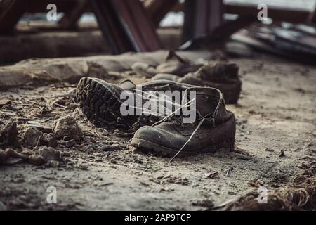 Vecchie scarpe polverose in una casa abbandonata. Foto Stock