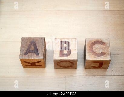 Alfabeto di legno blocca l'ortografia abc su pavimento in legno duro. Giocattoli educativi per i bambini in età prescolare e asilo. Foto Stock