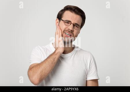 Testa ritratto sano giovane uomo sensazione di dolore nei denti. Foto Stock