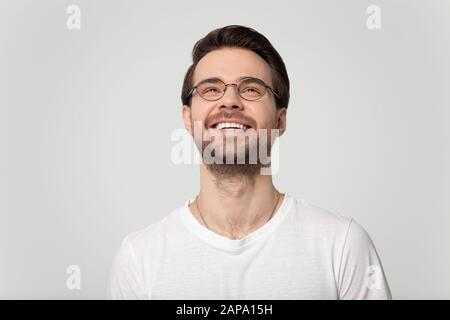 Testa fucilata primo piano su uomo felice millennial che guarda in su. Foto Stock