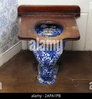 Un lavabo a motivi floreali blu e bianco - La Combinazione di Doulton. Un grande sedile in legno copre la ciotola. Foto Stock