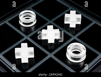 Vetro tic-tac-toe gioco su sfondo nero Foto Stock