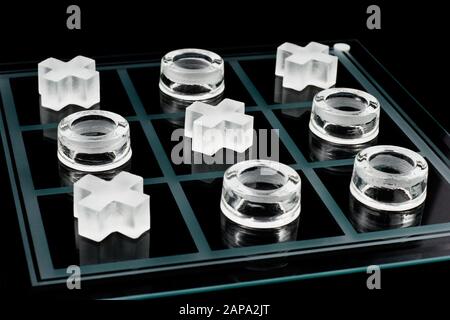 Vetro tic-tac-toe gioco su sfondo nero Foto Stock